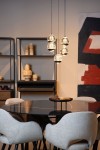 Lampa wisząca Sentubal z pięcioma kulistymi kloszami, czarna, z wbudowanym oświetleniem LED (5x5,2W). Zawieszona w poziomie nad okrągłym stołem, w tle minimalistyczna aranżacja z regałem i abstrakcyjnym obrazem.