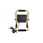 Naświetlacz LED przenośny 50W z czarnym korpusem, żółtą ramą, z uchwytami z miękkiego materiału. Widoczny kabel z wtyczką. Produkt ustawiony na stojaku, tyłem do kamery, ukazując jego konstrukcję oraz elementy mocujące. Wodoodporny, IP65.