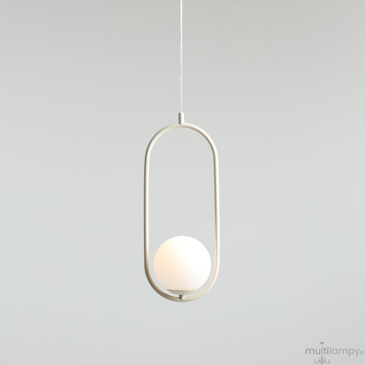 Kremowa lampa wisząca Riva o jednopunktowym źródle światła, z okrągłym kloszem w białym kolorze, umieszczona w metalowej ramie w kształcie elipsy. Produkt zawieszony na cienkim przewodzie, na jednolitym tle.