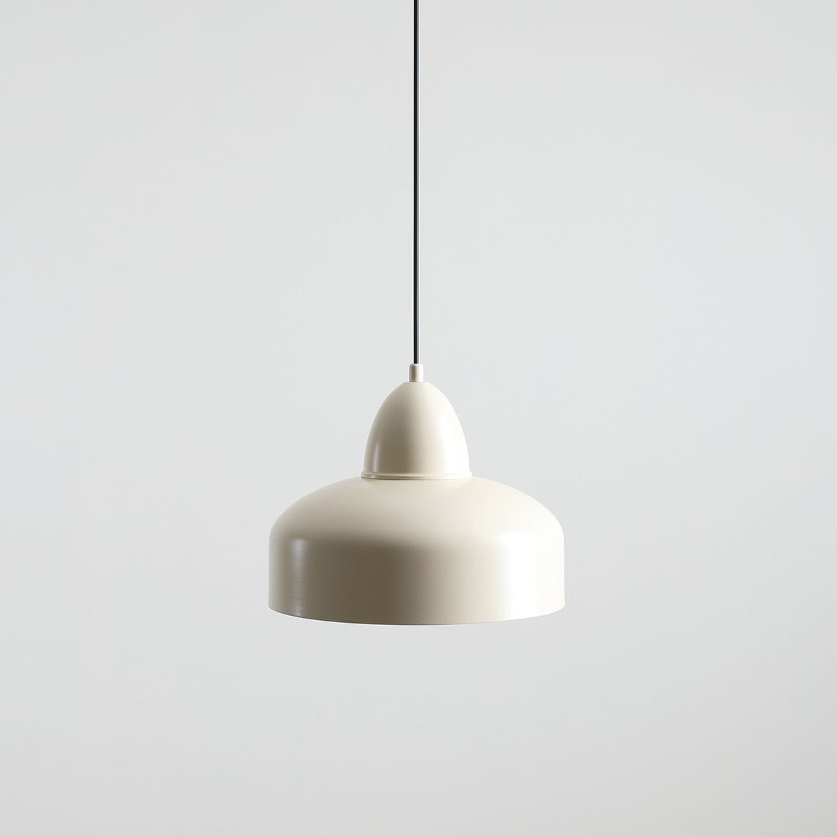 Lampa wisząca Como Cream w kolorze kremowym, z metalowym kloszem w kształcie dzwonu. Ujęcie frontalne, zawieszona na cienkim czarnym przewodzie, na jednolitym jasnym tle. Idealna do nowoczesnych wnętrz.