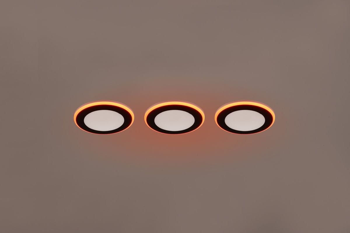 Oprawa do zabudowy Argus, czarna, z trzema okrągłymi panelami LED, podświetlona na pomarańczowo. Ujęcie frontalne, produkty zamontowane w suficie, z widocznymi białymi kloszami. Wymiary i detale nieczytelne.