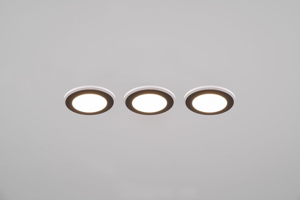 Oprawa do zabudowy Argus RGBW z pilotem, czarna, z trzema okrągłymi źródłami światła LED. Widok z góry, zamontowana w sufit, z białym pierścieniem i ciemnym obrzeżem. Światło białe i kolorowe, 6xLED 4W+1W.