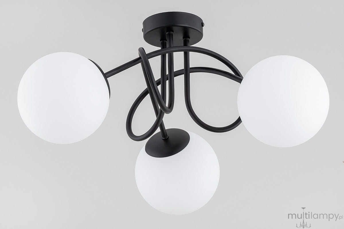 Lampa sufitowa Banko 3xE14 w kolorze czarnym z trzema okrągłymi kloszami z matowego szkła. Ułożona w efektowny sposób, z przewodami w stylu industrialnym. Montaż sufitowy. Tło jasne, neutralne.