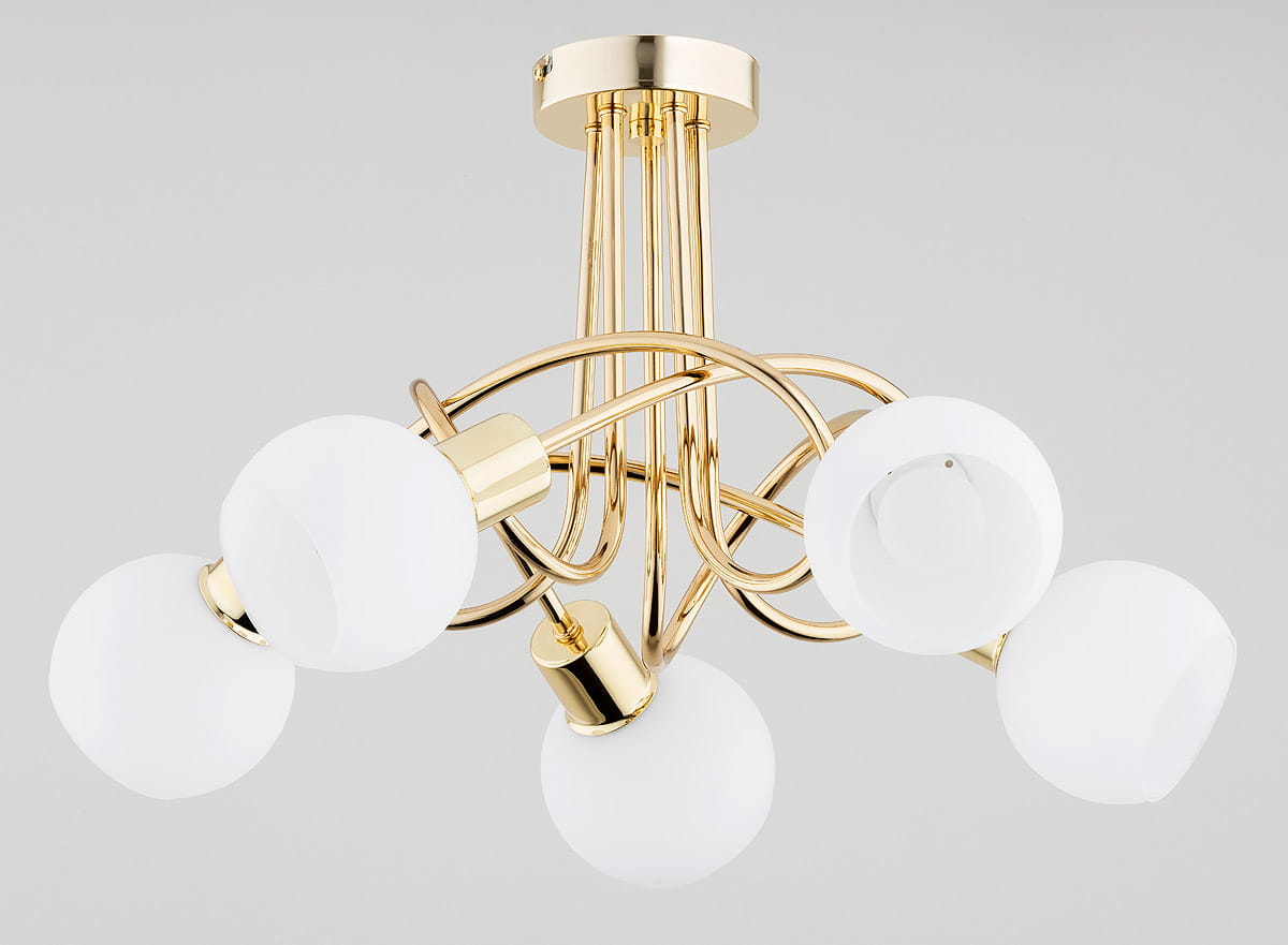 Lampa wisząca Eryka z pięcioma oprawami E14, złota. Konstrukcja z metalowych, błyszczących ramion, zakończona białymi, okrągłymi kloszami. Ujęcie z dołu, ukazujące detale wykończenia oraz kształt kloszy. Tło w jasnoszarym kolorze.