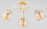 Lampa sufitowa Amarillo z trzema kloszami E27 w złotym wykończeniu. Klosze w odcieniu przezroczystego brązu, o zaokrąglonym kształcie, umieszczone na falistych ramionach. Całość na gładkim, złotym stelażu.