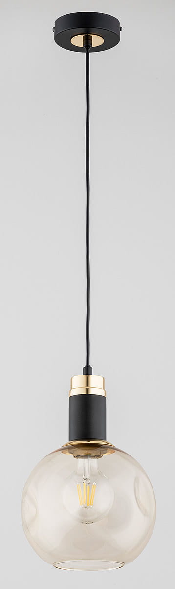 Lampa wisząca Adel z jedną oprawą E27, w kolorze czarnym i złotym. Szklany klosz w kształcie kuli, zawieszony na czarnym przewodzie. Metalowa podstawka z złotym wykończeniem. Idealna do modernistycznych wnętrz.