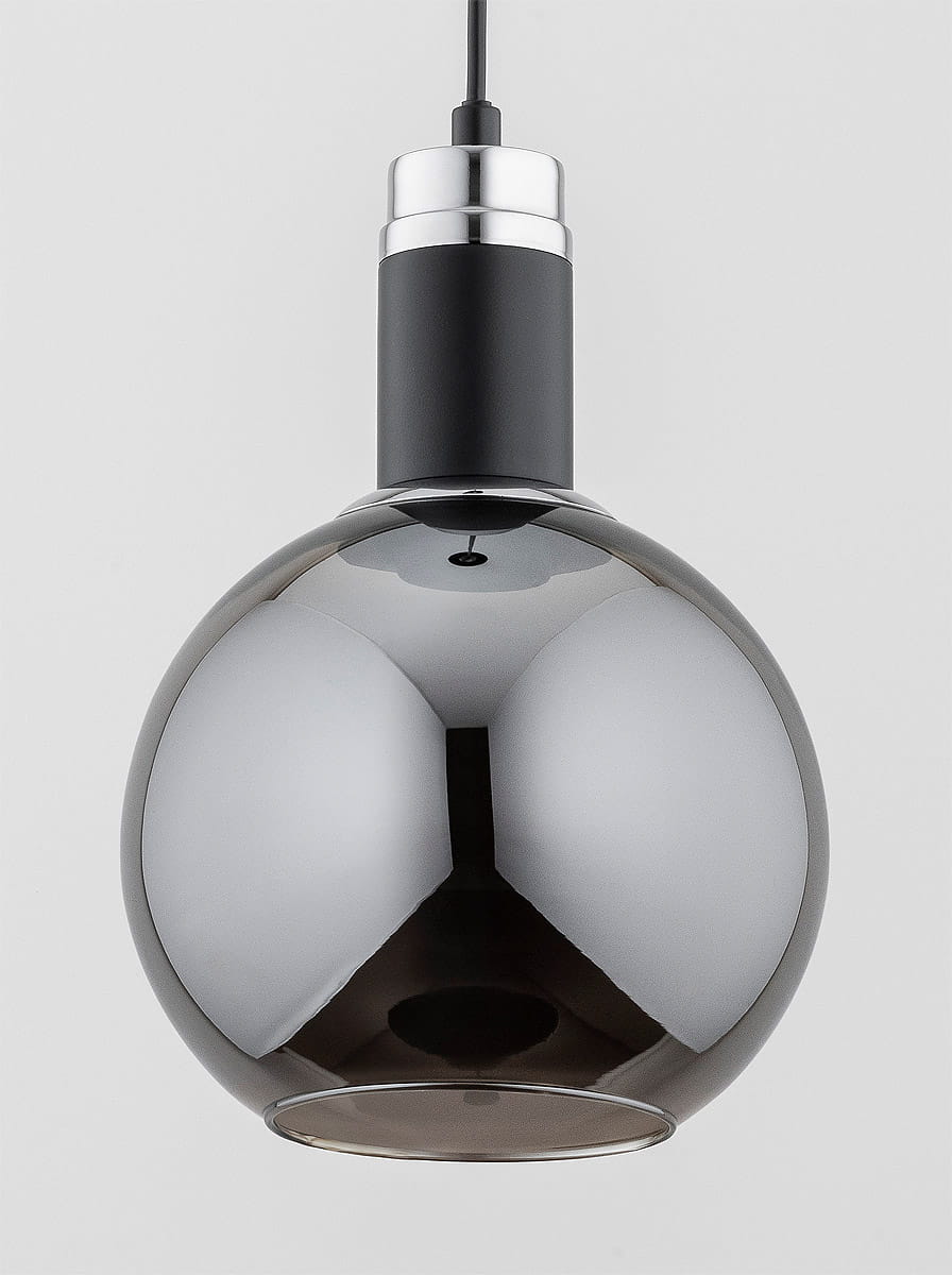 Lampa wisząca Adel w kolorze czarnym z chromowanym elementem, z okrągłym, szklanym kloszem o lustrzanej powierzchni. Ujęcie z góry, zawieszona na cienkim przewodzie, idealna do nowoczesnych wnętrz. Wymaga żarówki typu E27.