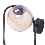 Kinkiet Venta 1xE14 w kolorze czarnym z bursztynową, szklaną kulą. Produkt zamontowany na ścianie, z metalową podstawą i elastycznym ramieniem. Kula lampy lekko przezroczysta, z widocznym gniazdem na żarówkę.