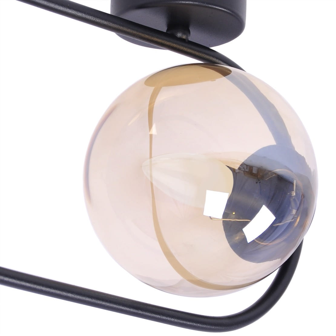 Kinkiet Venta 1xE14 w kolorze czarnym z bursztynową szklaną kulą. Lampa ma metalową konstrukcję z delikatnym, zaokrąglonym kształtem. Widoczna żarówka w środku oraz elementy mocujące. Ujęcie z góry, zbliżenie na detale.