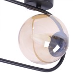 Kinkiet Venta 1xE14 w kolorze czarnym z bursztynową szklaną kulą. Lampa ma metalową konstrukcję z delikatnym, zaokrąglonym kształtem. Widoczna żarówka w środku oraz elementy mocujące. Ujęcie z góry, zbliżenie na detale.
