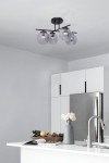 Lampa sufitowa Gamma w kolorze czarnym i grafitowym z czterema kloszami E14, zawieszona na prostym, metalowym stelażu. Klosze w odcieniu szaro-przezroczystym, umieszczone na poziomej belce, w nowoczesnej kuchni z białymi meblami.