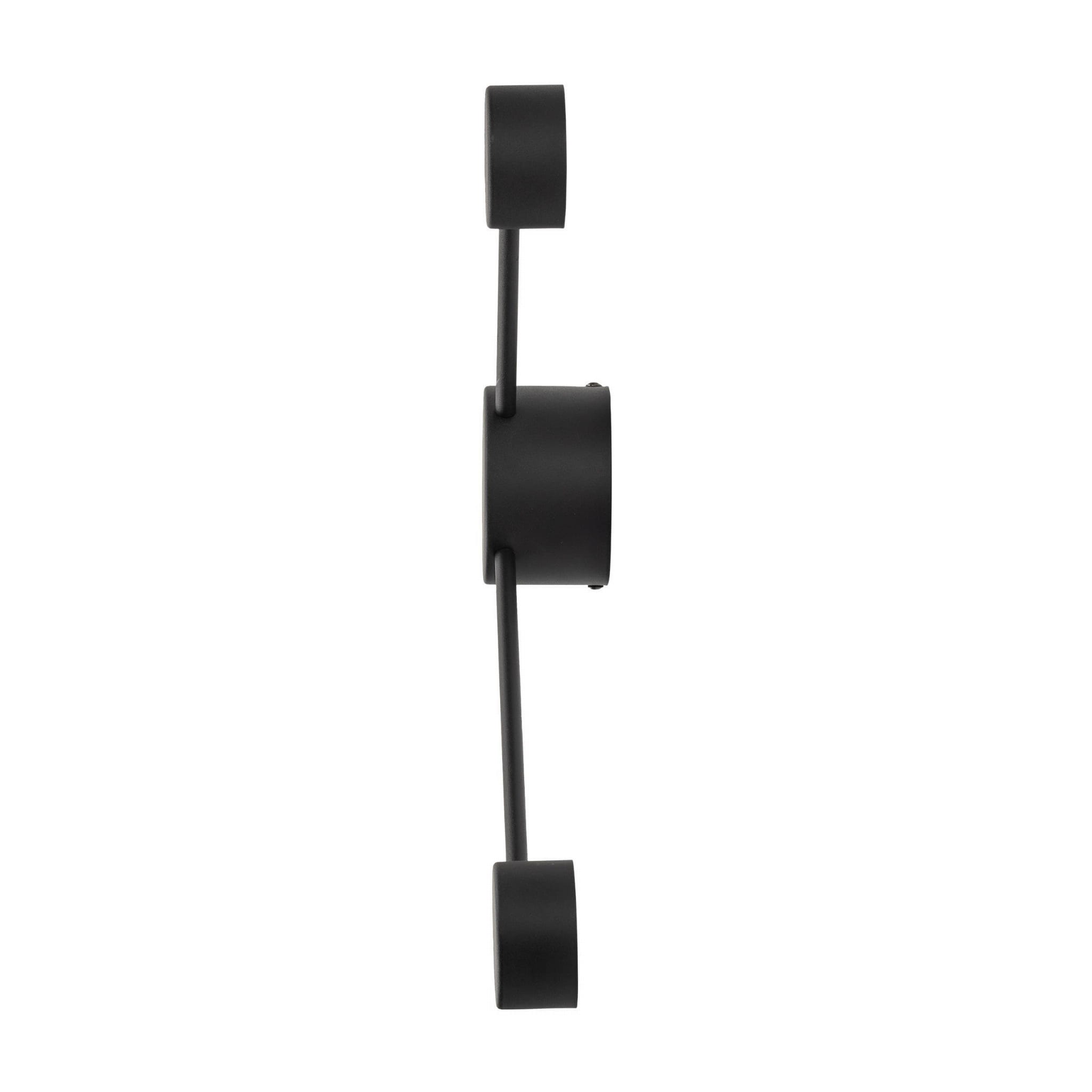 Kinkiet Avia w kolorze czarnym, wykonany z metalu, z dwoma okrągłymi oprawami na żarówki typu GX53. Ujęcie z boku, produkt zamontowany na ścianie, minimalistyczny design bez dodatkowych zdobień.
