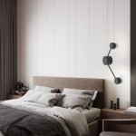 Kinkiet Avia 2xGX53 w kolorze czarnym, zamontowany na ścianie obok łóżka. Posiada dwa okrągłe źródła światła połączone cienką ramą, w minimalistycznym stylu. Tło w jasnych odcieniach, z widoczną pościelą i meblami w sypialni.