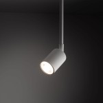 Reflektor spot Tracer 1xGU10 w kolorze białym, zamontowany na cienkiej rurze. Oświetlenie skierowane w dół, z okrągłym kloszem o gładkiej powierzchni. Tło ciemne, podkreślające nowoczesny design lampy.