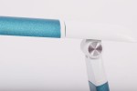 Zielona lampka biurkowa Niko z LED o mocy 5W. Ujęcie z boku, ukazujące metaliczny, błyszczący korpus i białą, prostokątną głowicę. Widoczny ruchomy staw, umożliwiający regulację kąta. Tło białe, co podkreśla kolor lampki.