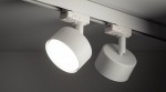 Reflektor Tracer 1xGX53 do szyny 3-fazowej w kolorze białym, zamontowany na szynie. Okrągła głowica z matowym wykończeniem, emitująca jasne światło. Widoczna jest także druga, nieaktywowana głowica. Tło ciemne, co podkreśla produkt.