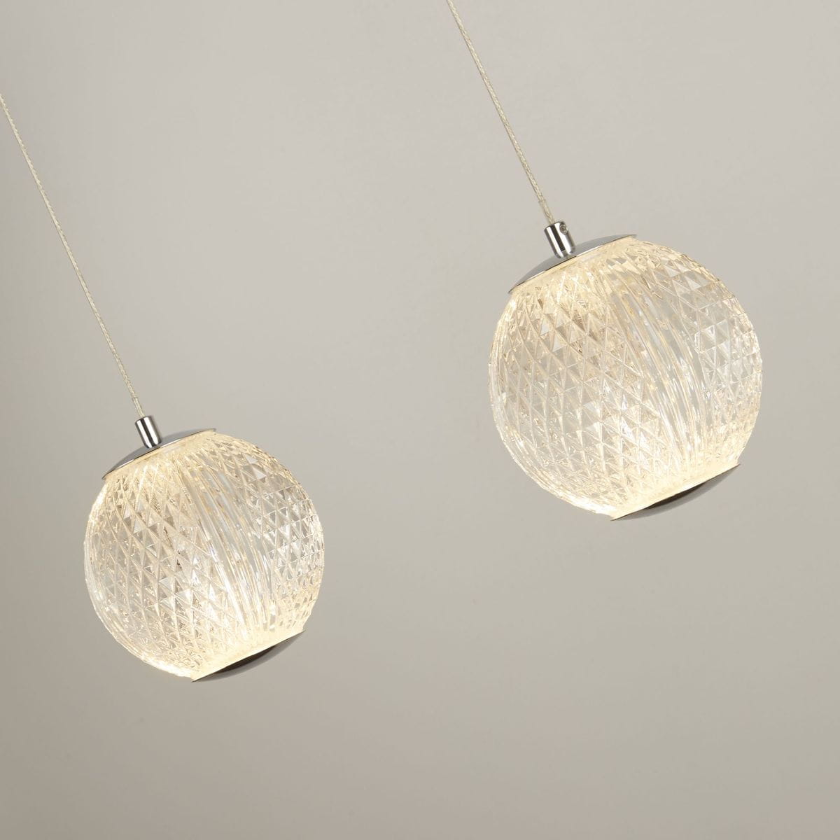 Lampa wisząca Allure 5xLED/28W w kolorze chromu z przeźroczystymi, szklanymi kloszami w kształcie kul, ozdobionymi diamentowym wzorem, zawieszona na cienkich linkach, w ustawieniu frontalnym.