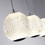 Lampa wisząca Allure z pięcioma kloszami LED o mocy 28W, w chromowanej oprawie. Klosze mają przezroczystą, teksturowaną powierzchnię w kształcie kul, zawieszone na cienkich linkach, na szarym tle.
