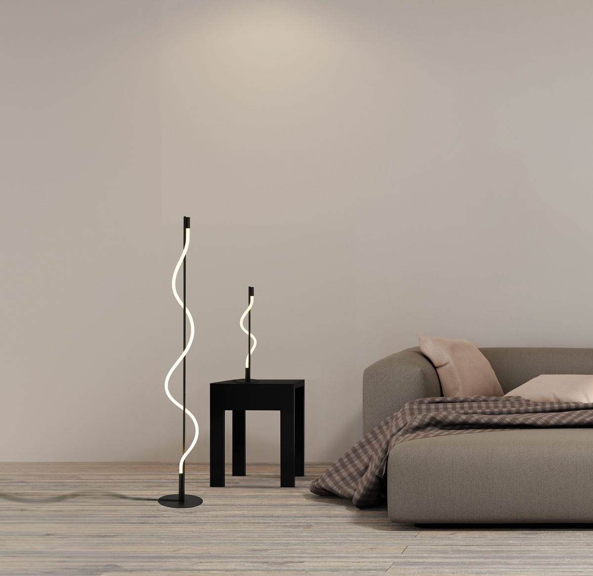 Czarna lampa podłogowa Serpent LED z jedną żarówką 20W, o falującym kształcie. Ujęcie z boku, stojąca obok mniejszej lampy na czarnym stoliku, w nowoczesnym wnętrzu z szarym sofą i drewnianą podłogą.
