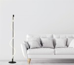 Czarna lampa podłogowa Serpent z jedną żarówką LED 20W, o spirali z ciepłego światła. Ustawiona obok białej sofy z poduszkami, na jasnym tle, z okrągłą podstawą i smukłym, minimalistycznym designem.