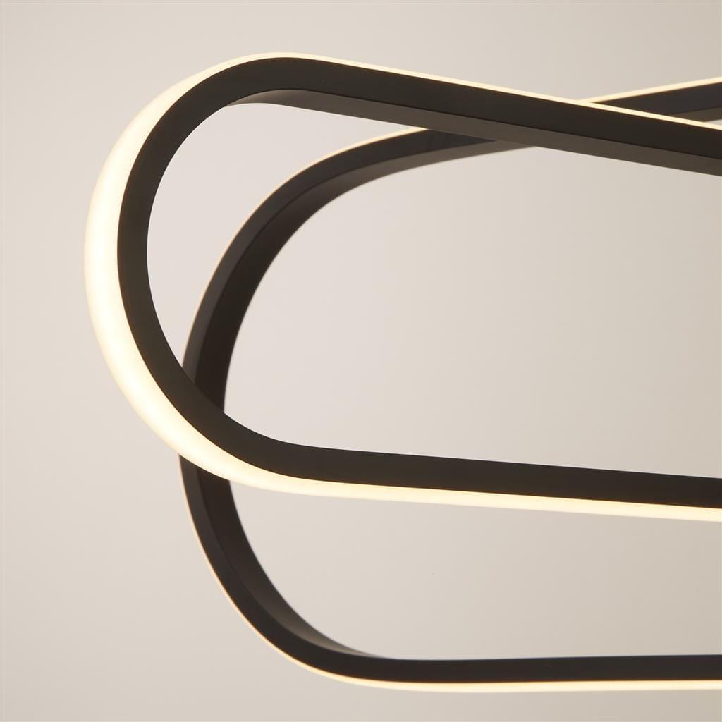 Czarna lampa wisząca Clip z trzema diodami LED, o nowoczesnym designie. Widoczne zakrzywione kształty oraz podświetlane krawędzie. Lampa zawieszona w górnej części, na jednolitym tle. Idealna do nowoczesnych wnętrz.