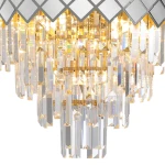 Lampa sufitowa Carisma 9xE14 w kolorze chromu, z dekoracyjnymi kryształowymi elementami. Widać lśniące, przezroczyste wiszące kryształy oraz geometryczny, lustrzany wzór na górnej części. Produkt umieszczony w pozycji wiszącej.