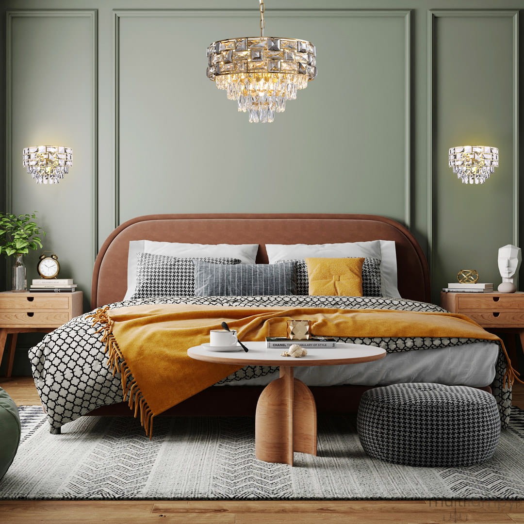 Lampa wisząca Luxuria 9xE14 w kolorze złotym, o okrągłym kształcie z kryształowymi zdobieniami, zawieszona w eleganckiej sypialni. W tle widoczna ciemna ściana oraz nowoczesne meble.