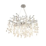 Lampa wisząca Cindy w chromowanym wykończeniu z 10 miejscami na żarówki G9. Stylizowana na gałązki, ozdobiona kryształowymi elementami w kształcie liści, zwisającymi w różnych długościach. Ujęcie z góry, wisi na cienkich linkach.