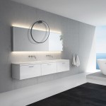 Kinkiet Saturno D50 w kolorze czarnym z jedną diodą LED o mocy 25W, IP44. Zamontowany powyżej lustra w nowoczesnej łazience, z minimalistycznym tłem w odcieniach szarości i bieli. Widoczny stylowy, okrągły detal.