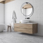 Kinkiet Saturno D80 w kolorze czarnym z jedną diodą LED o mocy 46W, z certyfikatem IP44. Produkt zamontowany na ścianie w łazience, w towarzystwie okrągłego lustra i drewnianej szafki. Tło w jasnych odcieniach z kafelkami.