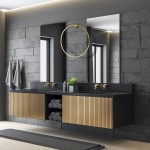 Kinkiet Saturno D80 w kolorze złotym, wykonany z metalowych elementów, zawiera 1xLED/46W, IP44. Zamontowany na ścianie, w nowoczesnej łazience z ciemnymi płytkami i drewnianą szafką, obok lustra i rośliny dekoracyjnej.