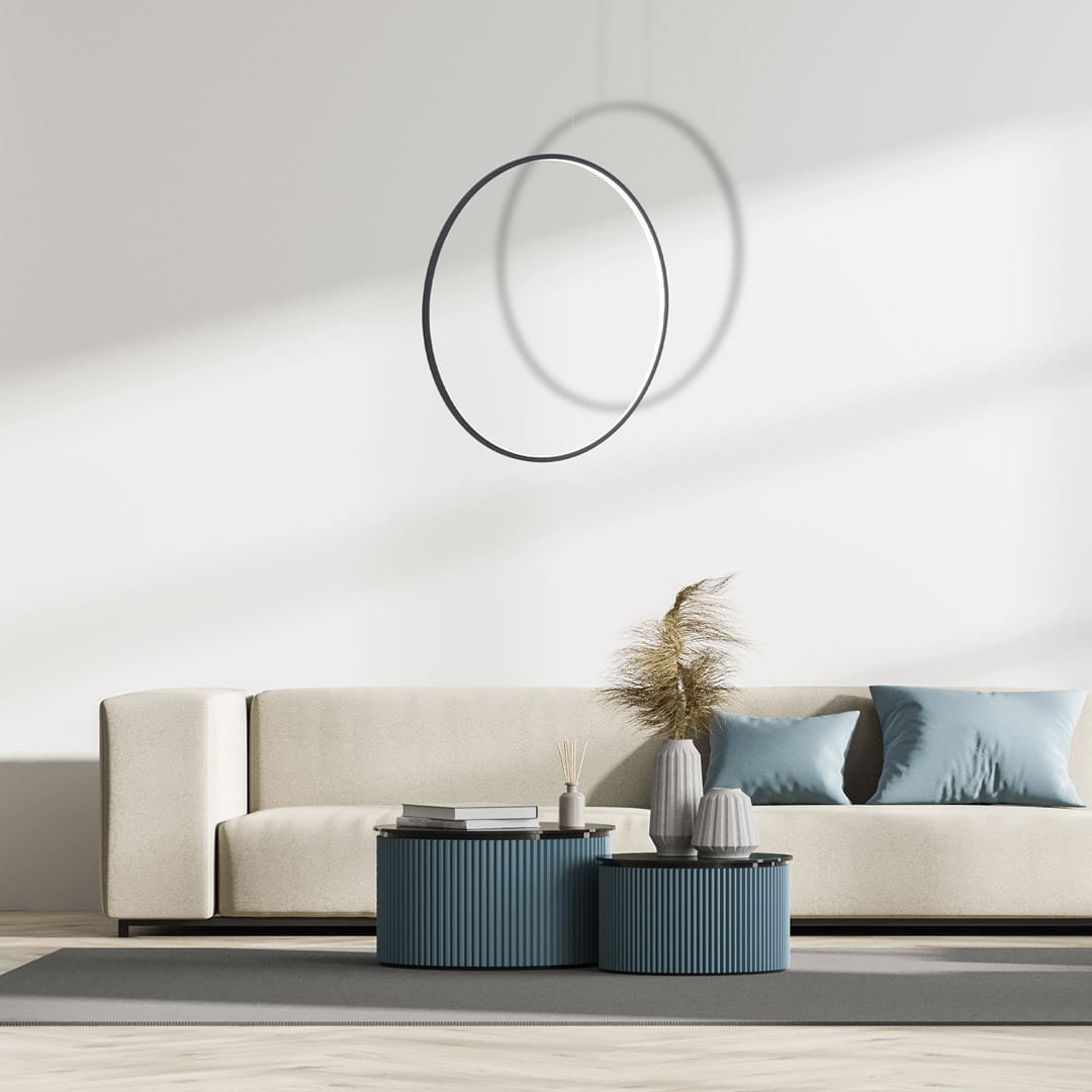 Lampa wisząca Saturno D80 w kolorze czarnym, z okrągłym kształtem, zawieszona nad sofą. Wykonana z materiałów odpornych na wilgoć (IP44), z wbudowanym źródłem LED o mocy 46W. W tle widoczny stół z dekoracjami i sofą w jasnym kolorze.