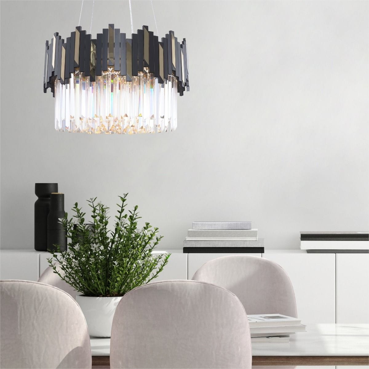 Lampa wisząca Rotta 6xE14 w kolorze złotym i czarnym, z geometrycznym kloszem z przezroczystych elementów, zawieszona nad stołem w nowoczesnym wnętrzu. W tle widoczne rośliny i książki na półce.