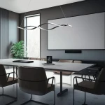 Lampa wisząca Grant 2xLED/38W w kolorze czarnym, o falistym kształcie, zawieszona nad stołem w nowoczesnym wnętrzu biurowym. W tle widoczne okno, roślina oraz ekran projektora.