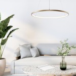 Lampa wisząca Breno D80 w kolorze złotym, o okrągłym kształcie, zawieszona nad kanapą. Wyposażona w 1 żarówkę LED o mocy 36W, emitująca miękkie światło. W tle widoczna roślina oraz stół z okrągłym blatem.