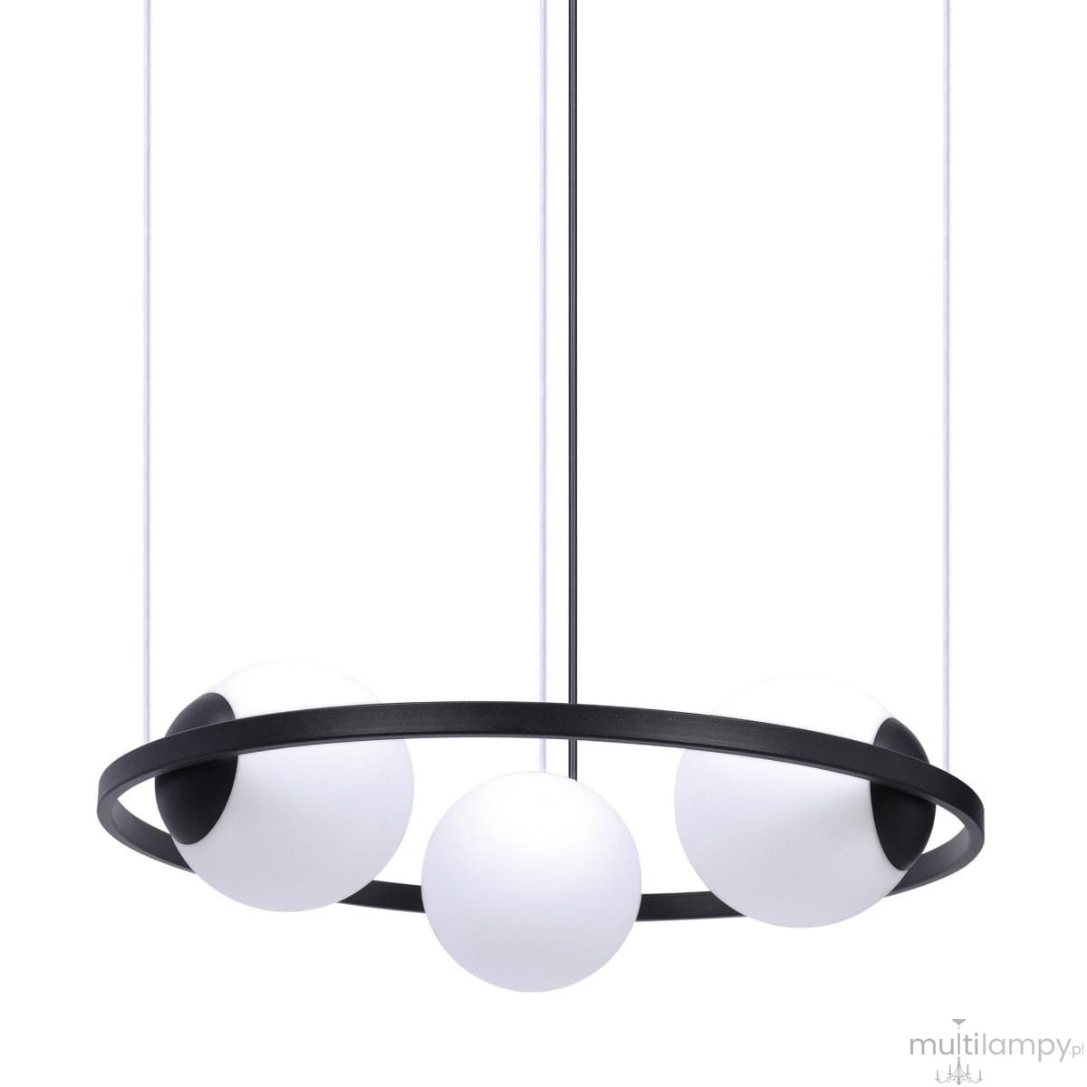 Lampa wisząca Orbit z trzema źródłami światła E27 w kolorze czarnym i białym. Okrągła, metalowa konstrukcja z czarnym ringiem i białymi, szklanymi kulami. Zawieszona na cienkich linkach, prezentuje minimalistyczny design.