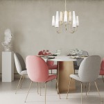 Złoty żyrandol Magnum z dziesięcioma kloszami E14 w białym kolorze, zawieszony nad okrągłym stołem, otoczony eleganckimi krzesłami w odcieniach różu i szarości. W tle widoczna rzeźba na białej podstawie.