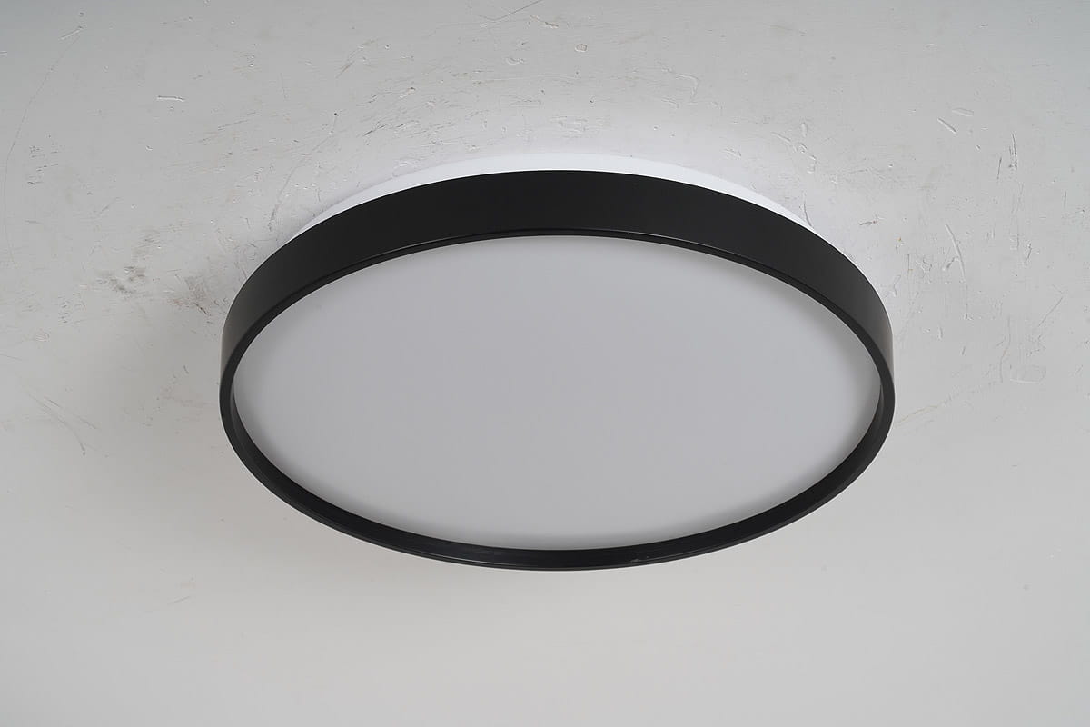 Plafon LED Filo D34 o średnicy 34 cm, z białym, matowym kloszem i czarną, metalową ramką. Ujęcie z boku, montowany na suficie, idealny do nowoczesnych wnętrz. Temperatura barwowa 4000K.