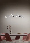 Lampa wisząca Perugia LED w kolorze chromu, umieszczona nad stołem. Posiada nowoczesny, falisty kształt. W tle widoczna drewniana stół oraz krzesła w odcieniach brązu, na ścianie jednolite tło w jasnym kolorze.