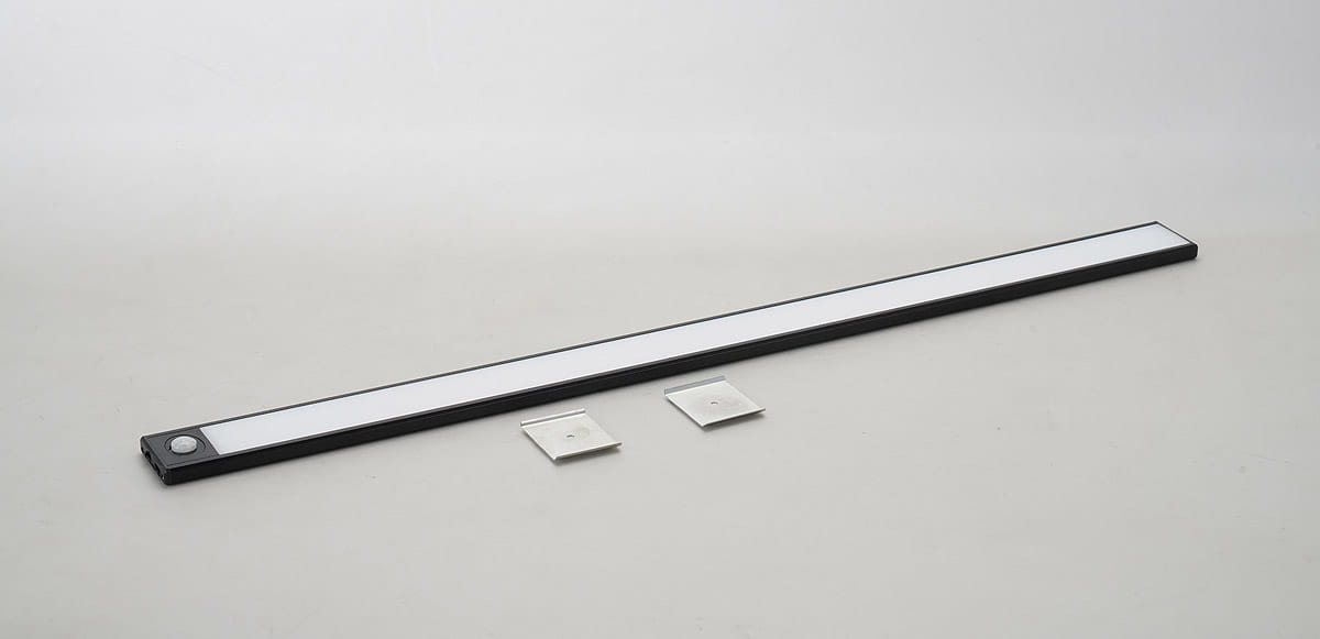 Listwa podszafkowa LED 60 cm w kolorze czarnym z czujnikiem ruchu. Produkt leżący poziomo, z białym światłem LED na całej długości. W zestawie dwa metalowe uchwyty montażowe. Tło jasne, proste.