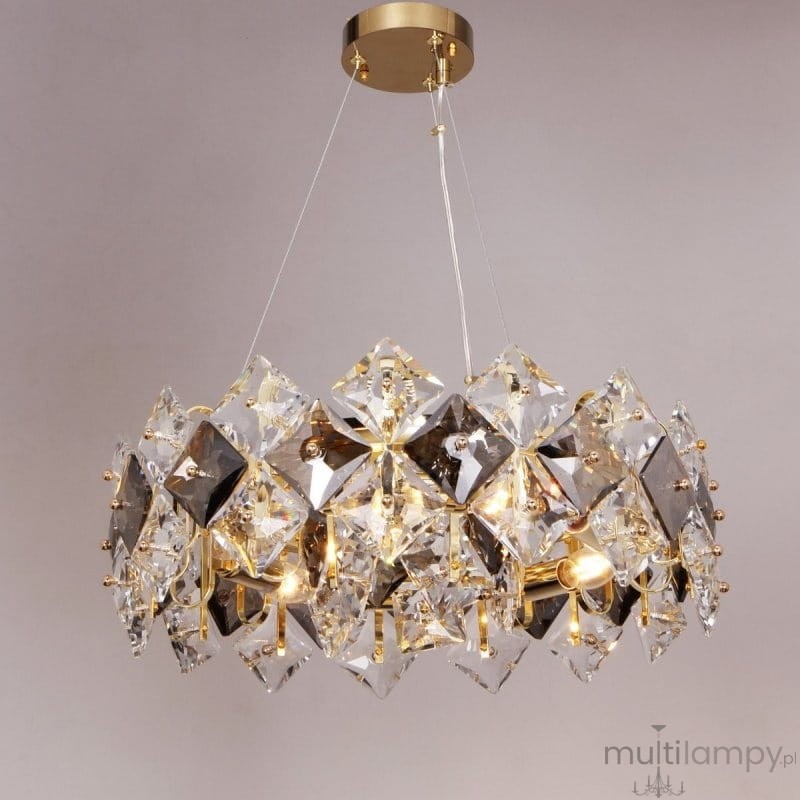 Lampa wisząca Tiara 6xE14 w kolorze złotym, ozdobiona kryształowymi elementami w kształcie diamentów. Produkt zawieszony na przezroczystych linkach, z widocznymi źródłami światła wewnątrz. Ujęcie frontalne, na jednolitym tle.