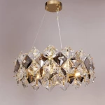 Lampa wisząca Tiara 6xE14 w kolorze złotym, ozdobiona kryształowymi elementami w kształcie diamentów. Produkt zawieszony na przezroczystych linkach, z widocznymi źródłami światła wewnątrz. Ujęcie frontalne, na jednolitym tle.