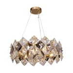 Lampa wisząca Tiara w kolorze złotym z sześcioma oprawami E14. Klosz wykonany z diamentowych, przezroczystych kryształów, podwieszony na cienkich żyłkach. Górna część z metalowego, złotego wykończenia.
