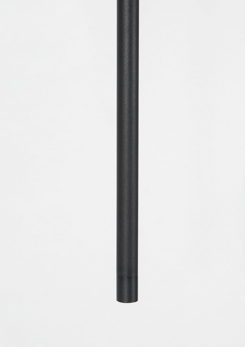 Lampa wisząca Buga w kolorze czarnym, wykonana z metalu, o cylindrycznym kształcie. Ujęcie frontalne, prezentujące smukły korpus. Element przeznaczony do montażu, z mocowaniem na sufit. Brak widocznych napisów lub logo.