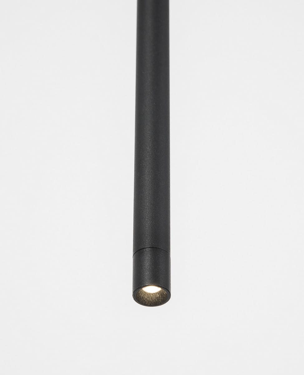 Lampa wisząca Buga w kolorze czarnym, wykonana z metalu, z pojedynczym źródłem światła LED o mocy 5W. Produkt ma prostą, cylindryczną formę, zawieszony w pozycji pionowej, emitujący światło z dolnej części. Tło białe.