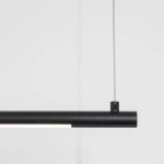 Czarna lampa wisząca Buga z jedną diodą LED o mocy 20W. Prosty, cylindryczny kształt z metaliczną teksturą. Zawieszona na cienkim, szarym przewodzie, na jednolitym, jasnym tle. Idealna do nowoczesnych wnętrz.