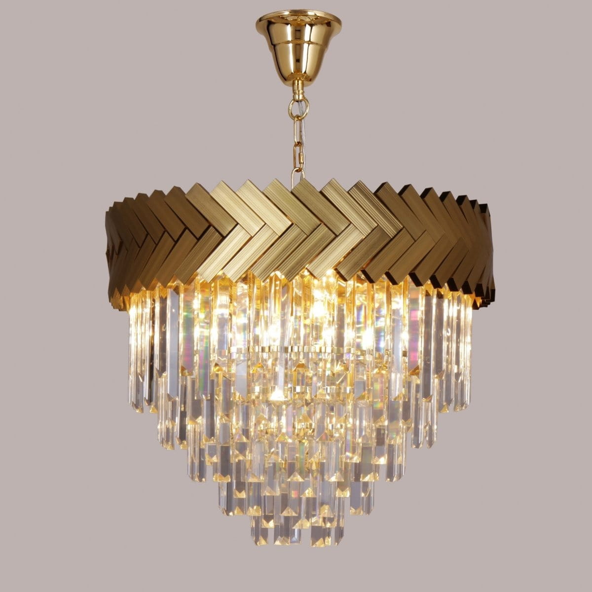 Lampa wisząca Lyon 9xE14 w kolorze złotym z dekoracyjną, plecioną górną częścią i kryształowymi zwisami. Ujęcie z dołu, ukazujące elegancki design i źródła światła. Tło jednolite, szare.