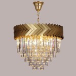 Lampa wisząca Lyon 9xE14 w kolorze złotym z dekoracyjną, plecioną górną częścią i kryształowymi zwisami. Ujęcie z dołu, ukazujące elegancki design i źródła światła. Tło jednolite, szare.
