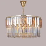 Lampa wisząca Camille o średnicy 16xE14, z złotą oprawą i transparentnymi kryształowymi detalami. Stylowy, okrągły klosz z dekoracyjnymi frędzlami, zawieszony na złotym łańcuchu. Idealna do eleganckich wnętrz.