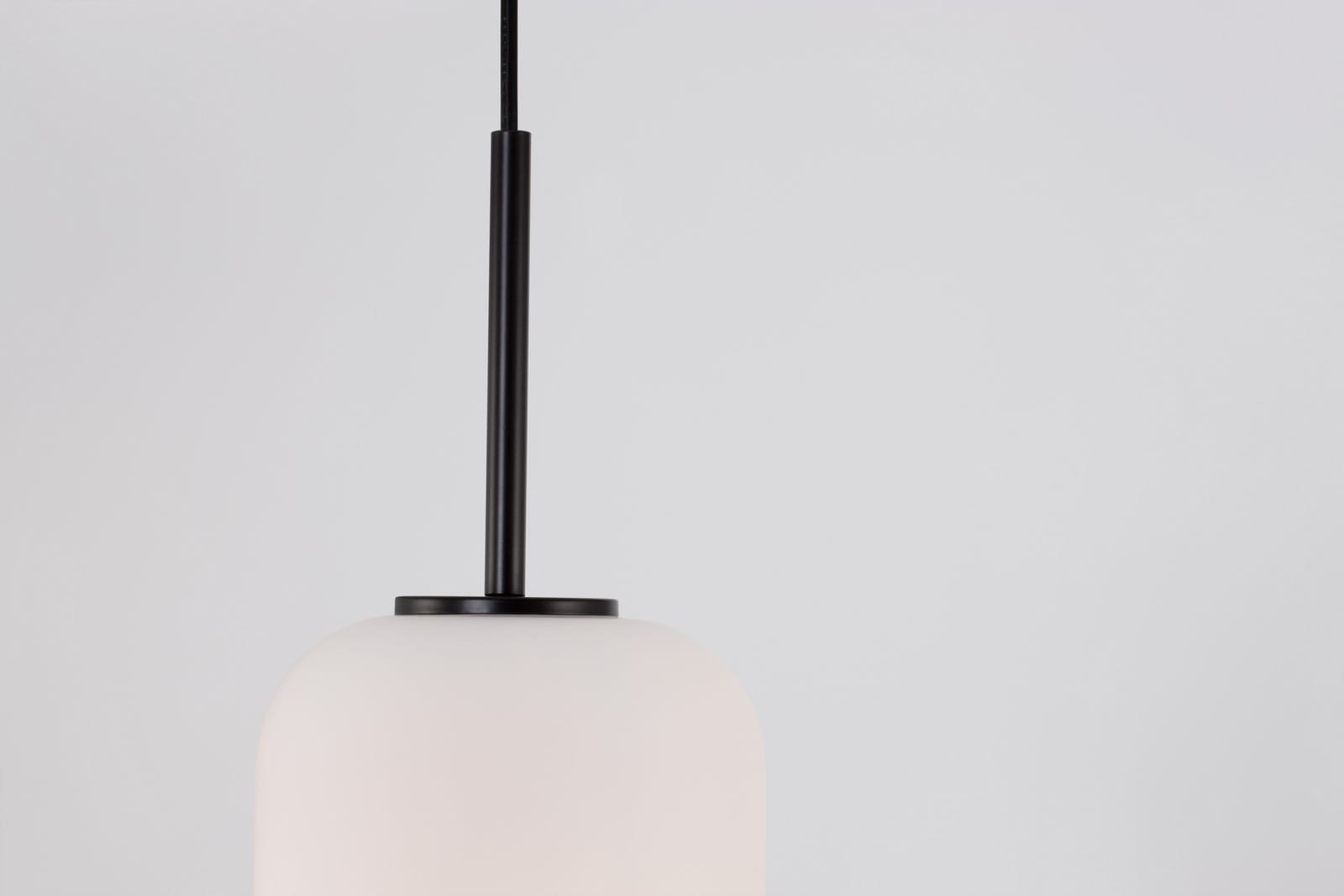 Czarna lampa wisząca Marc L D16,5 z kloszem w kształcie kulistym, wykonanym z matowego szkła. Ujęcie z góry, wisząca na cienkim kabelku. Pasuje do wnętrz nowoczesnych, idealna do oświetlenia stołu lub wyspy kuchennej.